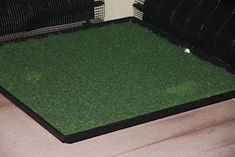 an open cage with grass in it on the floor