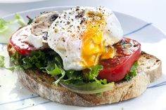 an egg and tomato sandwich is on a plate