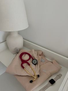 a pair of red scissors and a stethoscope on top of a tan shirt