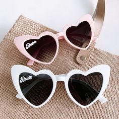 Bride and babe heart sunglasses make a cute bachelorette party favor for your bridesmaids - use them as a photo prop too for some really unique shots!  Each pair of sunglasses comes in your choice of bride in white or babe in pink or black retro, cat eye - heart shaped frames. Pink frames have a black gradient lens. Black frames have a pink mirrored lens. Style Chart Material: Acrylic. UV400. Size: 6"W x 5.75"L Bachelorette Gifts For Bridesmaids, Unique Shots, Glasses Bride, Bachelorette Sunglasses, Bachelorette Accessories, Style Chart, Brides Babes, Bachelorette Party Favor, Heart Shaped Frame