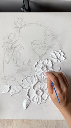 someone is drawing flowers on a piece of paper