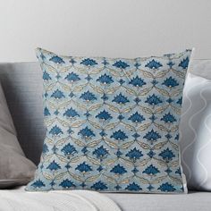 a blue and white pillow sitting on top of a couch