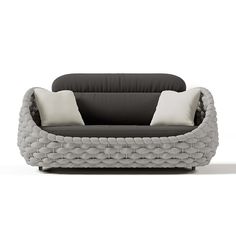 a black and white couch with two pillows on it's back end, in front of a white background