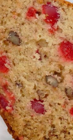 a piece of cake with strawberries and nuts on it sitting on top of a white plate