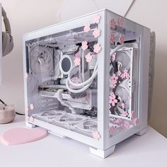 a white and pink computer case sitting on top of a desk next to a mouse