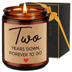 two years down, forever to go candle in front of a box with a yellow ribbon