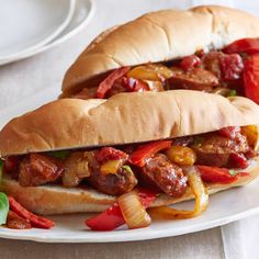 two sandwiches with meat and peppers on a plate