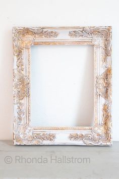 an ornate white frame sitting on top of a shelf