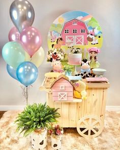 a birthday party with balloons, cake and farm animals on the table in front of it