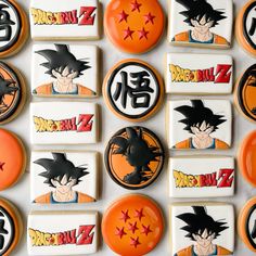 dragon ball cookies are arranged in rows on a white surface with black and orange designs