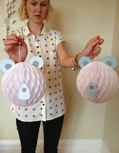 a woman is holding up some paper decorations