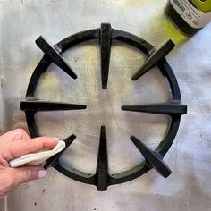 a person using a bottle opener to make a circular design on a metal table top