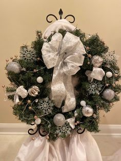 a christmas wreath with silver and white ornaments