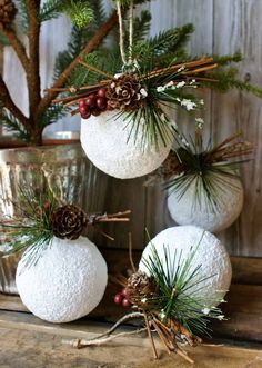 three white balls decorated with pine cones and berries