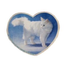 a white cat standing in front of a blue heart