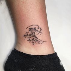 a small wave tattoo on the ankle