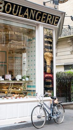 a bicycle parked in front of a bakery