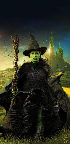 a woman dressed as the wizard holding a wand in her hand and wearing a hat