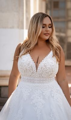 a woman in a wedding dress is posing for the camera with her hands on her hips