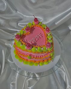 a heart shaped birthday cake sitting on top of a table