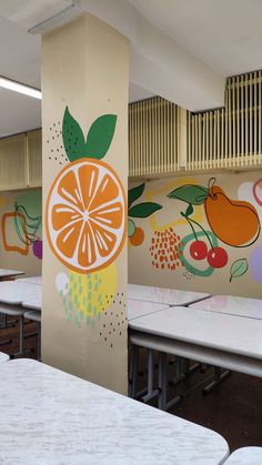 an orange painted on the side of a wall next to tables with chairs around it