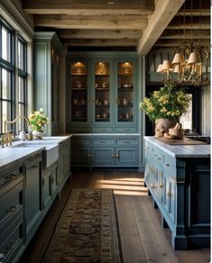 a kitchen with blue cabinets and white counter tops in front of a large chandelier