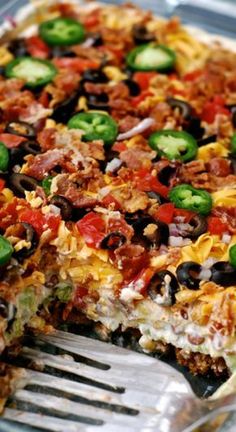 a large casserole with lots of toppings and a fork in the dish