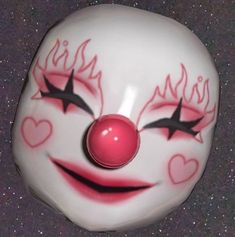 a close up of a clown's face on a surface