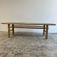 a wooden bench sitting on top of a carpeted floor next to a white wall