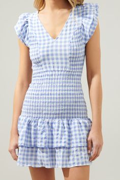 Go gingham in this perfectly smocked detail mini dress. Ruffle layer cap sleeves frame a V neckline and partially smocked bodice with princess seams to add a shapely figure. Smocking continues throughout the drop waist and ruffle layer details to finish off the dress. Pair it with pointed toe heels and a mini shoulder bag for a charming ensemble.- Ruffle layer details- Smocked- Princess seams- Drop waist- Comes in 2 ColorsSize + Fit - Model is 5'8" and wearing size XS- Measurements taken from si Gingham Dress With Smocked Bodice And Short Sleeves, Short Sleeve Gingham Dress With Smocked Bodice, Fitted Gingham Smocked Dress With Short Sleeves, Gingham Short Sleeve Dress With Smocked Bodice, Short Sleeve Gingham Smocked Dress For Summer, Gingham V-neck Dress With Ruffles, Short Sleeve Gingham Smocked Dress, Summer Gingham Smocked Fitted Dress, Gingham Smocked Dress For Picnics