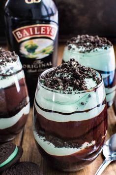 two glasses filled with ice cream and oreo cookies next to a bottle of bailey's