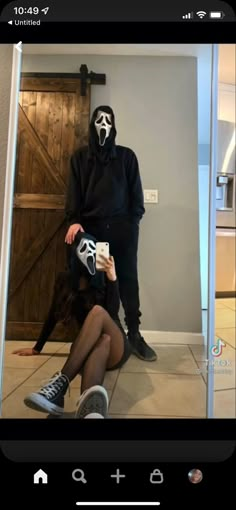 a person wearing a mask and sitting on the floor in front of a mirror with their legs crossed