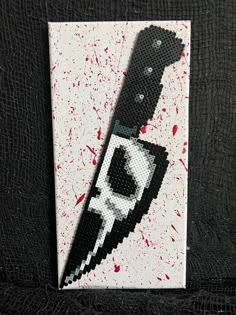 a piece of art that looks like a knife with blood splatters on it