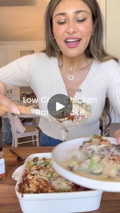 a woman holding a spoon over a bowl of food