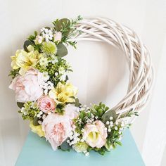 a wreath with flowers on top of a blue table