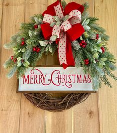 a christmas wreath with red and white bows hanging on a wooden wall next to a sign that says merry christmas