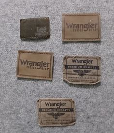 four old wrangler labels are laying on the floor next to an empty wallet