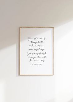 a white wall with a framed quote on it