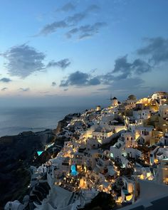 an image of a city at night with the ocean in the background