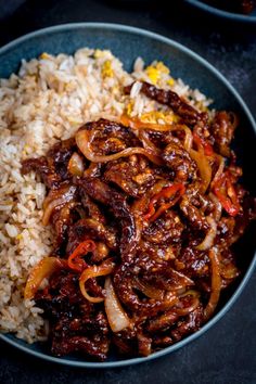 a bowl filled with rice and meat on top of a table