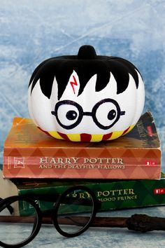 a harry potter pumpkin sitting on top of some books