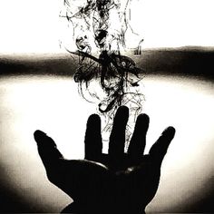 a black and white photo of a hand reaching for something in the air with it's fingers