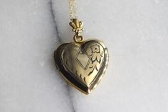 "Vintage gold filled heart locket from the 1940s. It has hand engraved designs including a little flower in the corner. Lockets from this era are referred to as \"Sweetheart Lockets\" because soldiers would purchase them for their wives and mothers. Era: 1940s Markings: WH 1/20 12k Material: Gold Filled Metal Condition: Good vintage condition. Both photo frames are intact. Opens and stays shut properly. Measurements: About 1\" in length including the bail. Comes with a new 18\" new gold filled c Vintage 14k Gold Locket Necklace, Vintage 14k Gold Locket Necklace Stamped 14k, Vintage Engraved Double Heart Necklace, Vintage Double Heart Engraved Locket Necklace, Vintage Personalized Heart Locket Necklace, Heirloom Engraved Locket Necklace For Valentine's Day, Personalized Vintage Heart Locket Necklace, Vintage Heart Charm Locket Necklace For Wedding, Vintage Double Heart Locket Necklace Keepsake