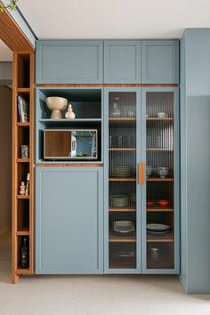 a kitchen with blue cupboards and glass doors