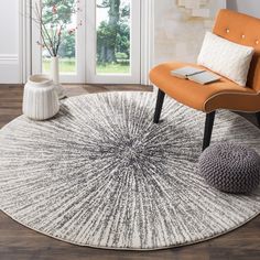 an orange chair sitting on top of a wooden floor next to a white and gray rug