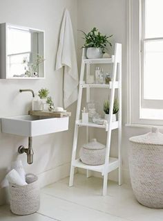 a white bathroom with a ladder shelf next to the sink