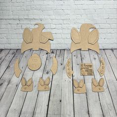 two cardboard cut outs with ears and tails on wooden floor next to white brick wall