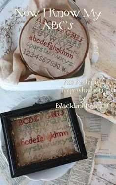 two cross - stitch samples in a box with the words now i know my abcu