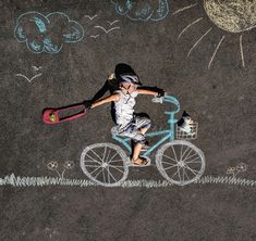 a person riding a bike with chalk drawings on the ground next to it and an umbrella