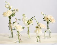 four vases with flowers in them on a table